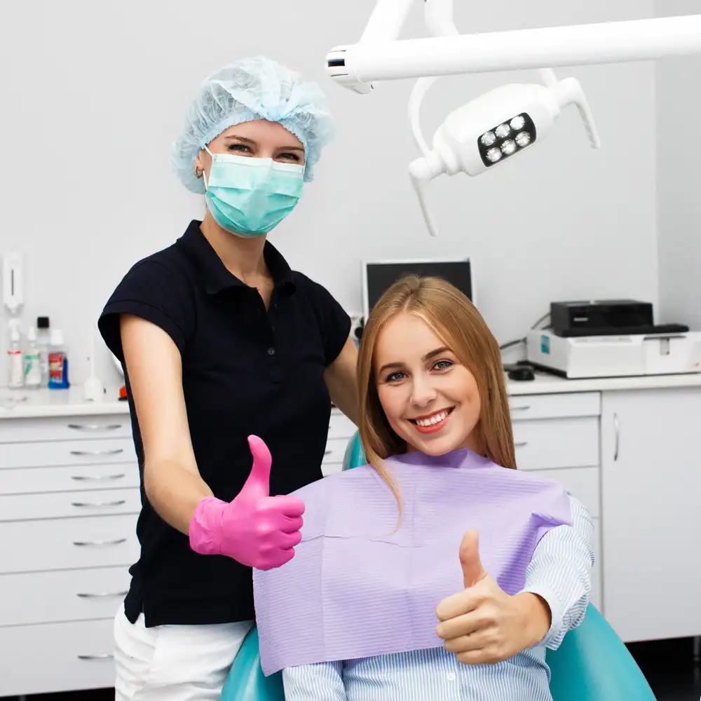 woman shows thumb up sitting with stomatologist dentist office copy
